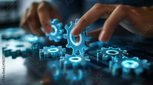 A person is touching a blue gear with their hand. The gears are all different sizes and colors