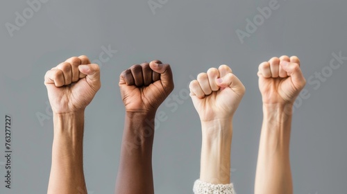 Hands of different people, of diverse race, skin color, gender raising fists up over grey background. Human rights and equality. Concept of human relation, community, togetherness, symbolism, culture 