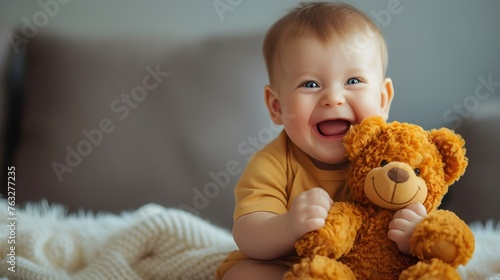 a baby holding a teddy bear in his arms on a grey background photo