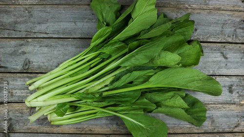 Fresh mustard, tomatoes and carrots vegetable isolated on gray wooden table.