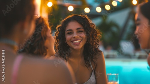Young woman chatting with new friends by the pool, her face lighting up with a smile