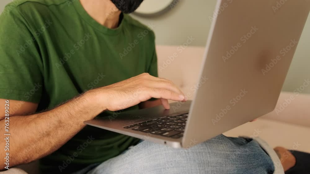 Close-up of a young man's hands working on a laptop Close-up of a young man's hands working on a laptop