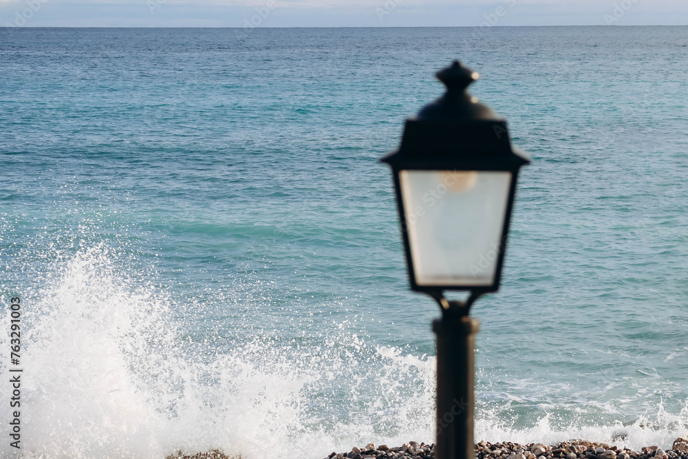 View of the Mediterranean Sea in Menton, with the lantern in the foreground out of focus
