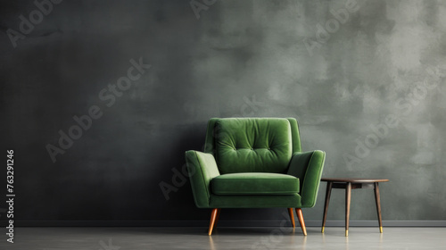 A green chair sits in front of a wall with a greyish color. The chair is the only piece of furniture in the room