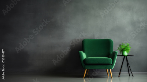 A green chair sits in front of a wall with a plant on a table. The room is empty and has a modern, minimalist feel