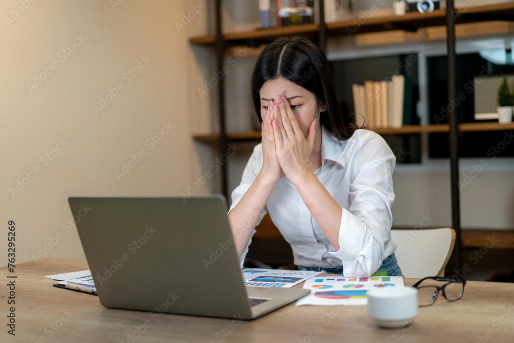 The woman is sitting at the computer working and feeling tired The woman is sitting at the computer working and feeling tired