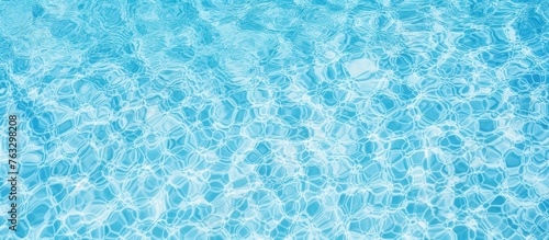 Close up of the liquid azure water in a swimming pool, creating an electric blue pattern that shimmers like a fluid organism in an aqua font