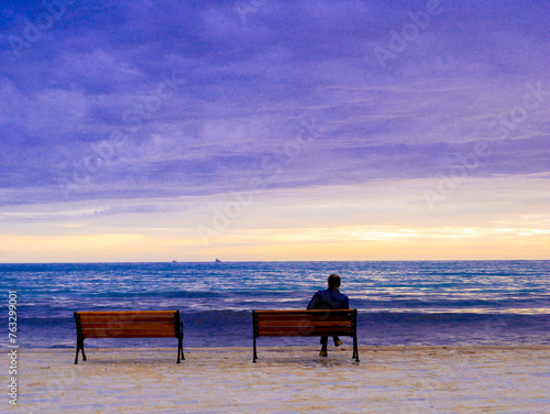 Person sits watching the sunset
