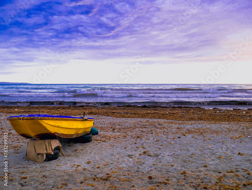 Yellow boat on the beach shore