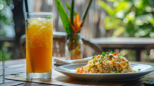 Orange juice and fried rice placed on a wooden table