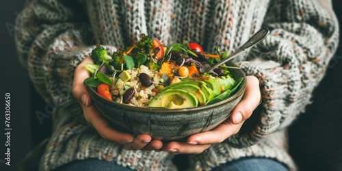 poke with vegetables, avocado, beans and broccoli in bowl in women's hands, healthy vegetable salad