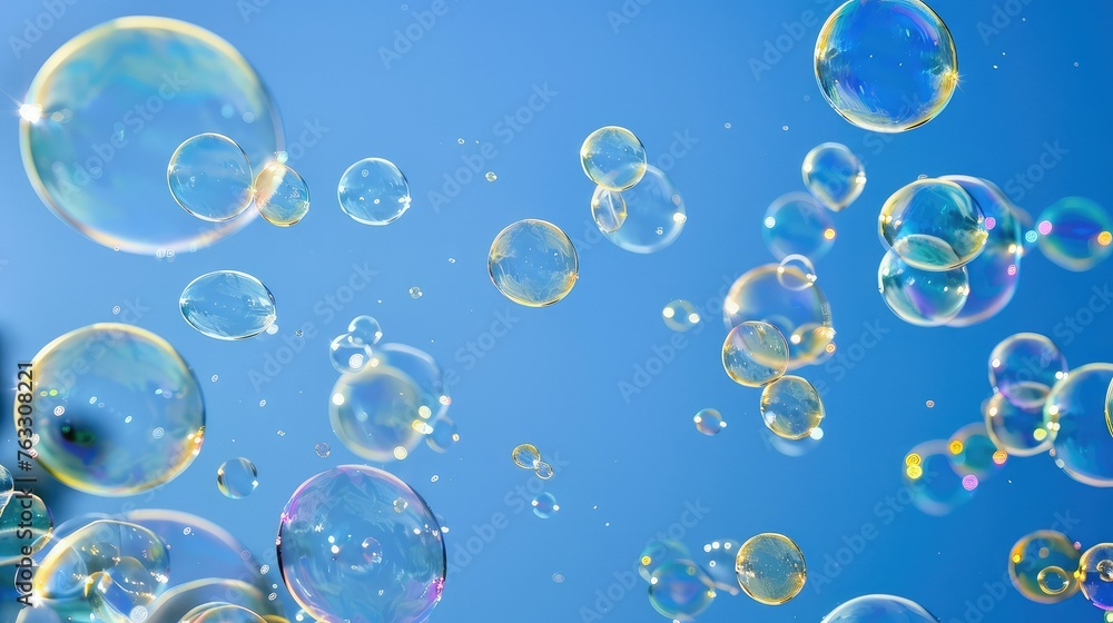 A lot small soap bubbles floating on clean blue sky background.