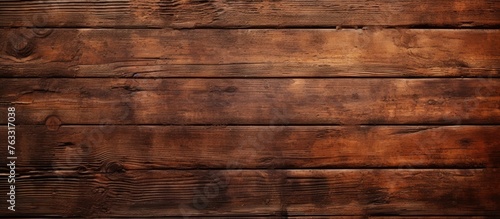 A close up of a brown hardwood rectangle wood stain flooring with amber tints and shades, against a blurred brickwork background