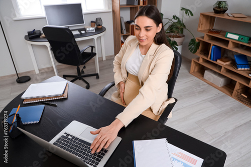 Pregnant businesswoman work...