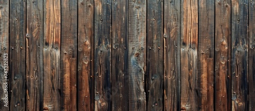 A closeup of a brown hardwood fence made of wooden planks with a beautiful natural wood pattern, varnished for protection