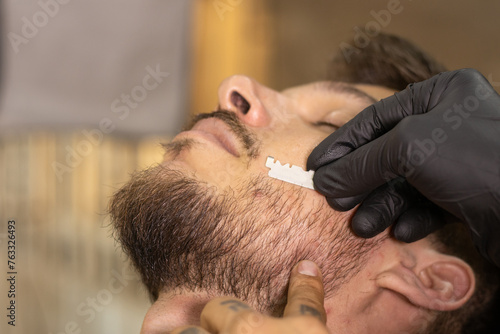 blond latin white man in a barbershop getting his hair cut with a beard in high resolution and high quality. barbershop concept