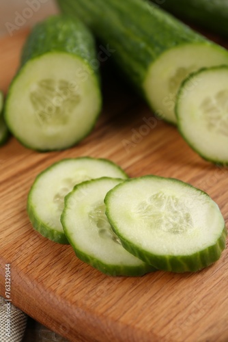 Fresh cucumbers on wooden cutting board, closeup
