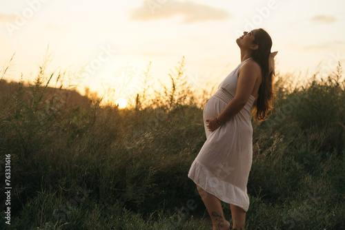 Mujer embarazada contemplando el atardecer