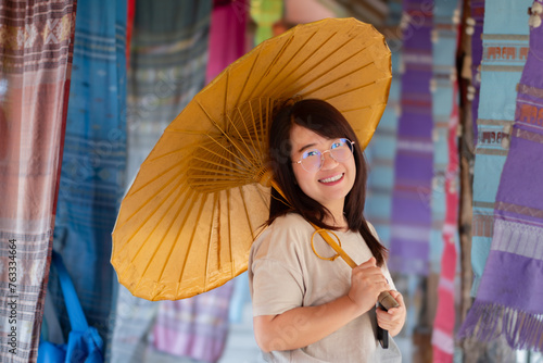 Asian young adult business woman with umbrella in local cafe.