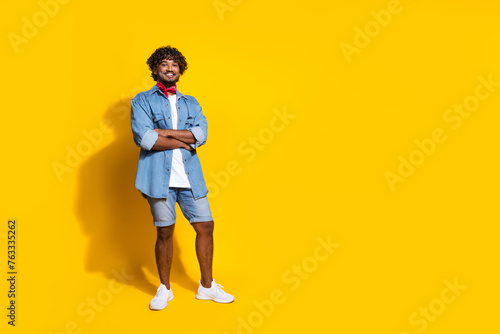 Full length photo of handsome young guy folded hands shopping dressed stylish jeans garment red scarf isolated on yellow color background