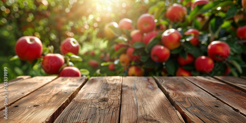 Empty wooden kitchen table over apple fruit garden background © Ricardo Costa