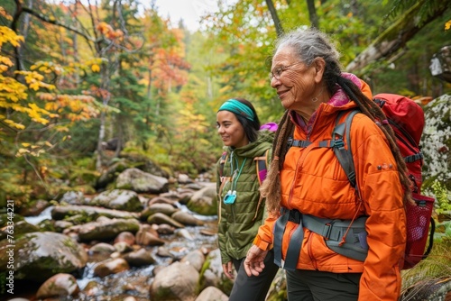 A photo of an elderly woman and her adult daughter hiking in the forest