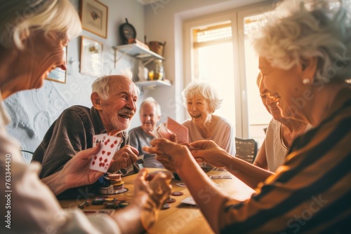 A group of happy elderly people are playing cards in the living room photo