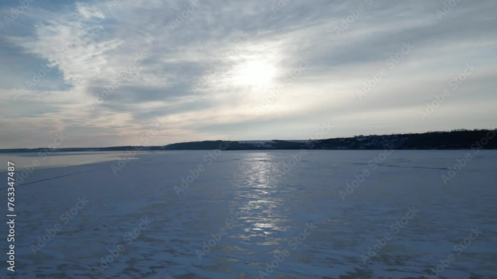 View from a drone. The shore is on the horizon. There is a crack in the ice. Big lake in winter. View from a drone. The shore is on the horizon. There is a crack in the ice. Big lake in winter.