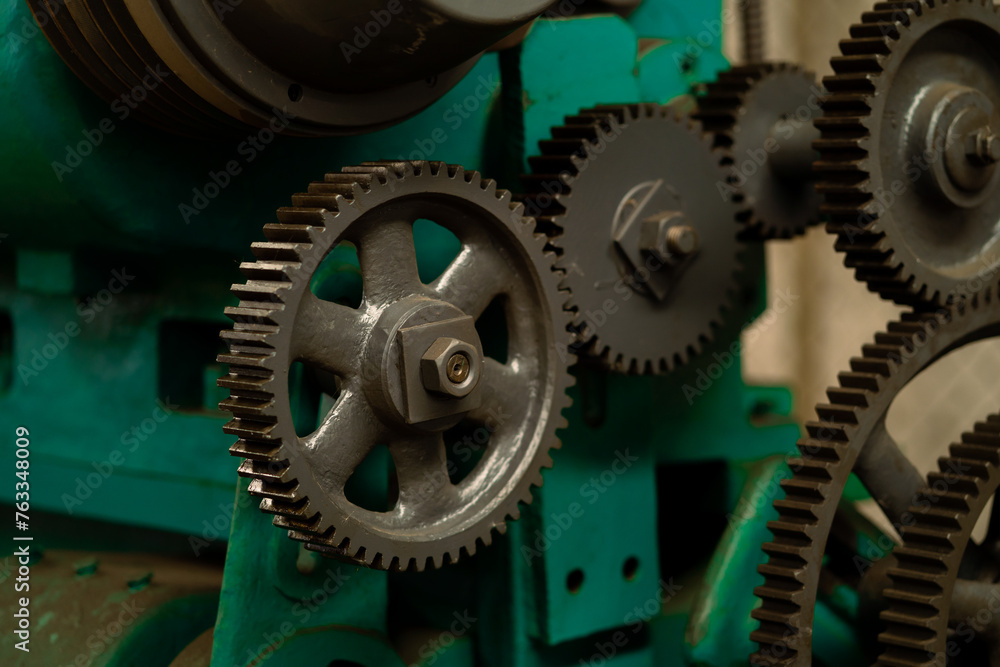 A machine with many gears, one of which is missing. The machine is green and has a metallic look A machine with many gears, one of which is missing. The machine is green and has a metallic look