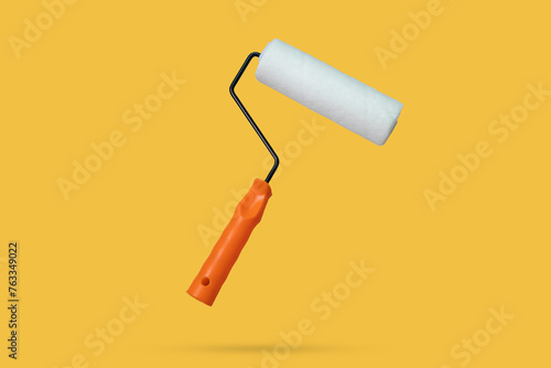 white paint roller floated on yellow background
