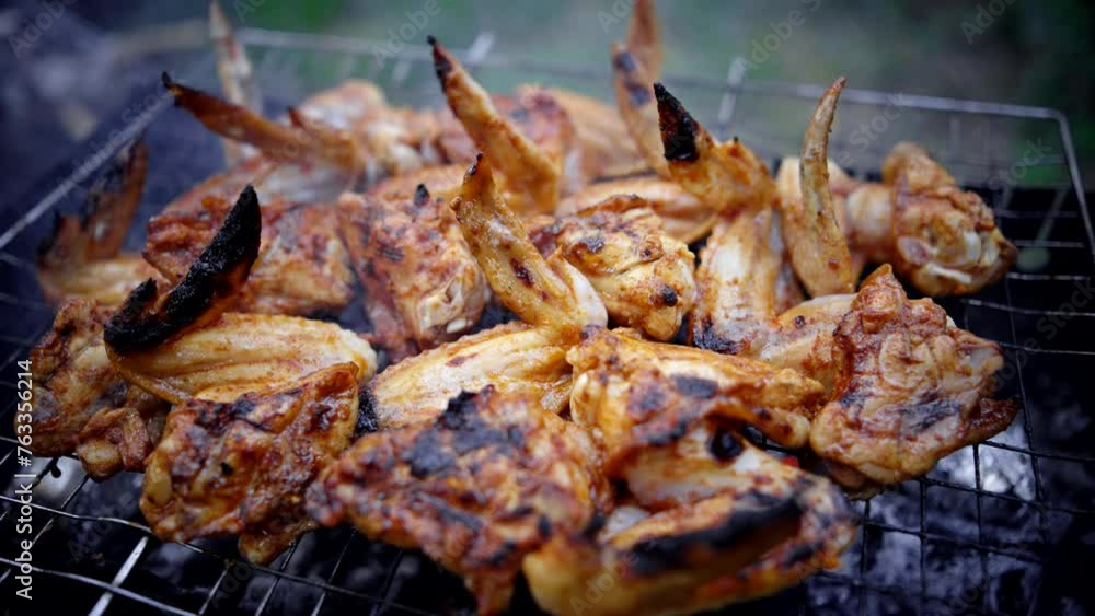 Poultry on the barbecue . Grilled marinated chicken wings Poultry on the barbecue . Grilled marinated chicken wings