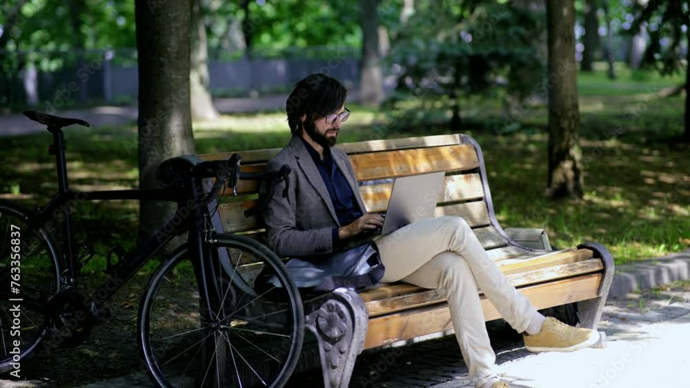Man sitting bench with computer overtime working outdoor Man sitting bench with computer overtime working outdoor