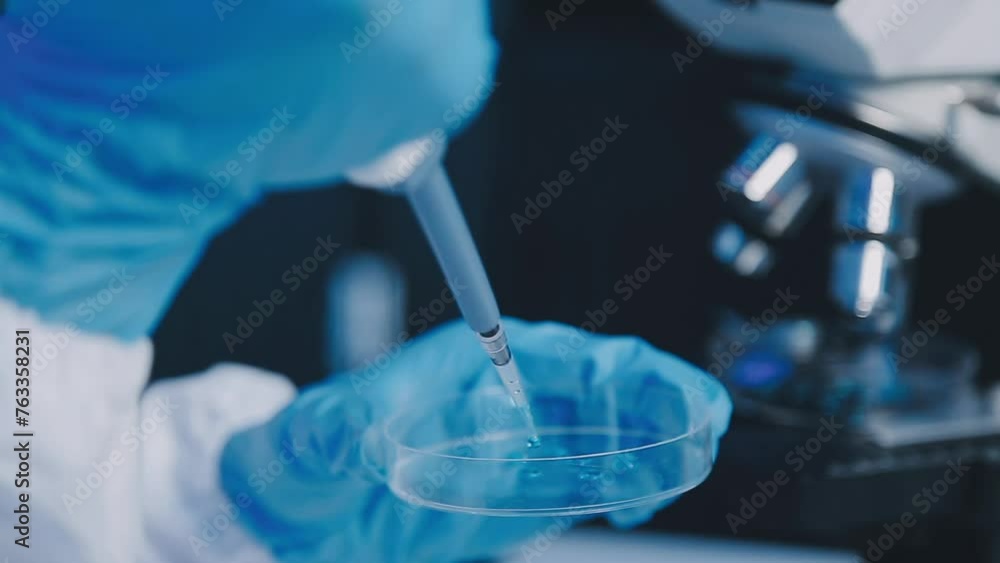 Young scientists conducting research investigations in a medical laboratory, a researcher in the foreground is using a microscope. Young scientists conducting research investigations in a medical laboratory, a researcher in the foreground is using a microscope.