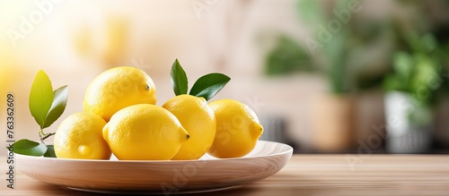 Close up of fresh lemons in a bowl on a kitchen table