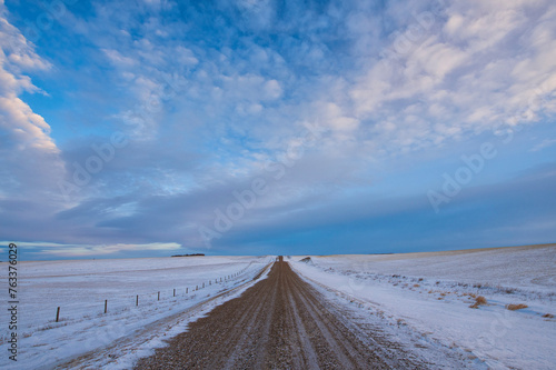 Road leading off into the distance in the wintery landscape in rural Saskatchewan; Assiniboia, Saskatchewan, Canada