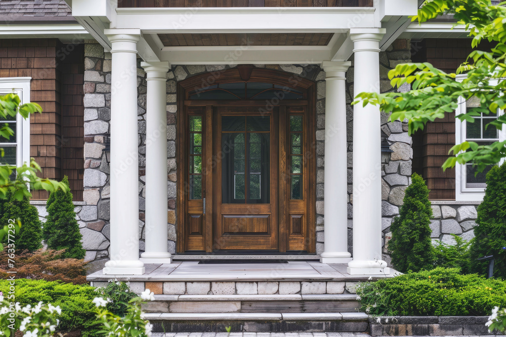 Front door of house is surrounded by pillars and a stone staircase leading up to it Front door of house is surrounded by pillars and a stone staircase leading up to it