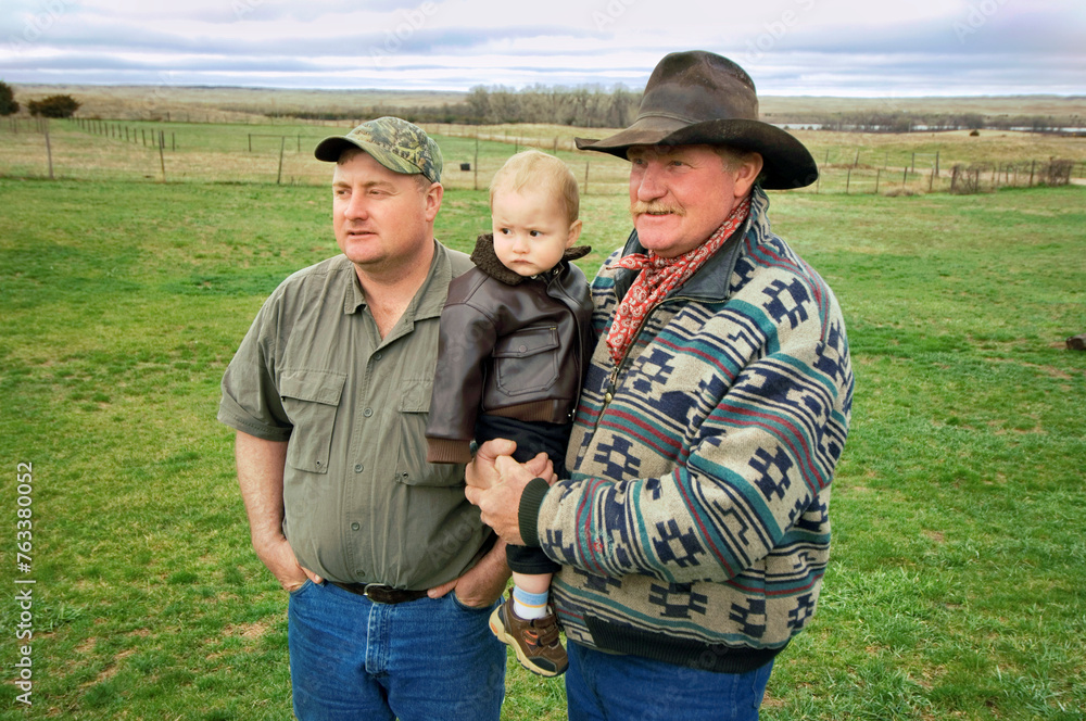Three generations, a father, son and grandson spending time together on a ranch; Gibbon, Nebraska, United States of America Three generations, a father, son and grandson spending time together on a ranch; Gibbon, Nebraska, United States of America