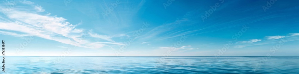 A clear blue sky over a calm sea, offering a vast expanse of water and sky for a tranquil summer backdrop with ample copy space