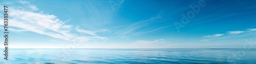 A clear blue sky over a calm sea  offering a vast expanse of water and sky for a tranquil summer backdrop with ample copy space