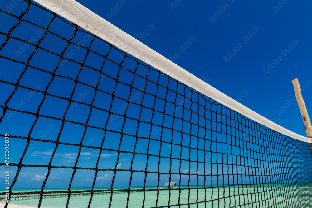 Close-up of the netting of a beach volleyball net against a blue sky and the Caribbean Sea; Cayo Guillermo, Cuba Close-up of the netting of a beach volleyball net against a blue sky and the Caribbean Sea; Cayo Guillermo, Cuba