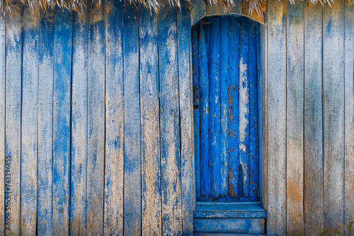 Weathered blue wooden door and wall; Cayo Guillermo, Cuba photo