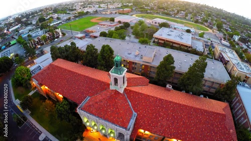 Aerial: Drone Backward Shot Of Public High School In Residential City Against Clear Sky - Culver City, California photo