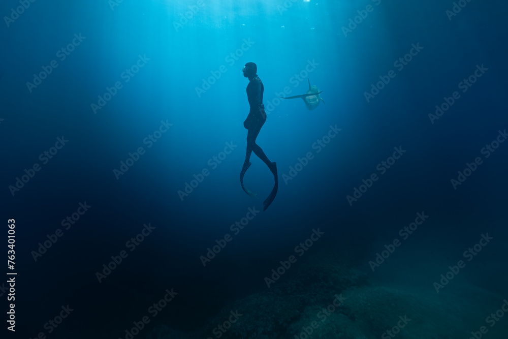 Freediver Swimming in Deep Sea With Sunrays. Young Man Diver Eploring Sea Life. - obrazy, fototapety, plakaty 