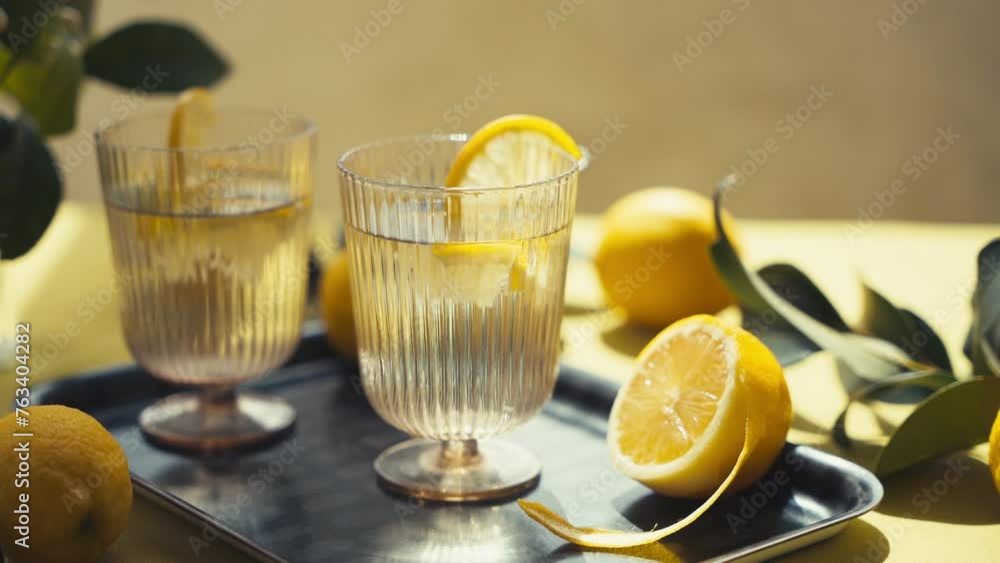 Close up of glasses of water with lemon on the table on a sunny summer day. Close up of glasses of water with lemon on the table on a sunny summer day.