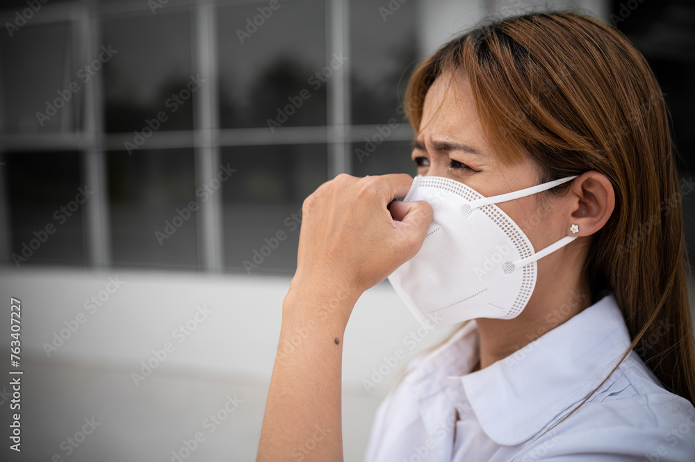 Asian woman wear N95 mask for protect dust pm 2.5,ecology concept. Allergy, headache. air danger in city. Asian woman wear N95 mask for protect dust pm 2.5,ecology concept. Allergy, headache. air danger in city.