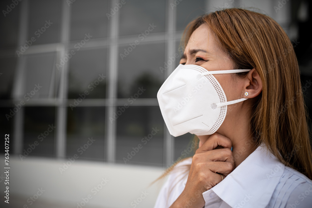 Asian woman wear N95 mask for protect dust pm 2.5,ecology concept. Allergy, headache. air danger in city. Asian woman wear N95 mask for protect dust pm 2.5,ecology concept. Allergy, headache. air danger in city.