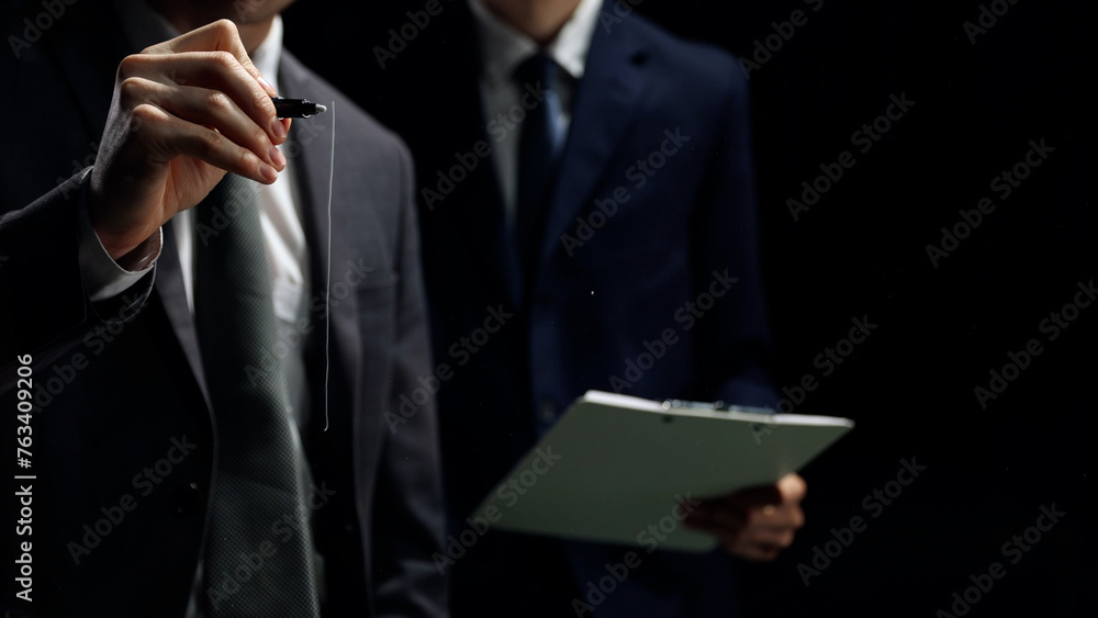 Businessmen in close-up discussing business in a dark office Businessmen in close-up discussing business in a dark office