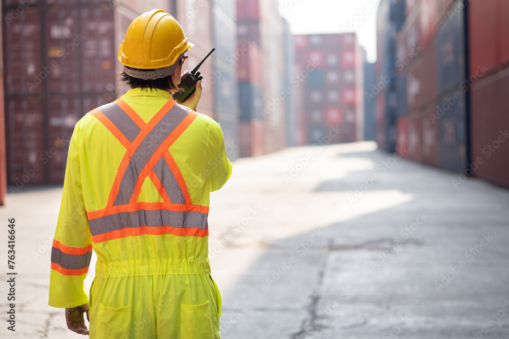 Asia logistic engineer man worker or foreman working with walkie talkie at container site Asia logistic engineer man worker or foreman working with walkie talkie at container site
