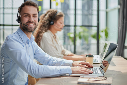 Customer Service Representative With Colleague Working In Office