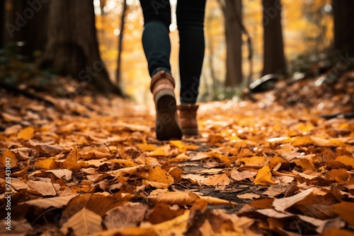 A close up of a person s feet walking along a forest path carpeted with fallen leaves  immersing in the sensory delights of autumn